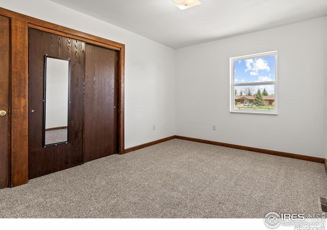 unfurnished bedroom featuring carpet flooring and a closet