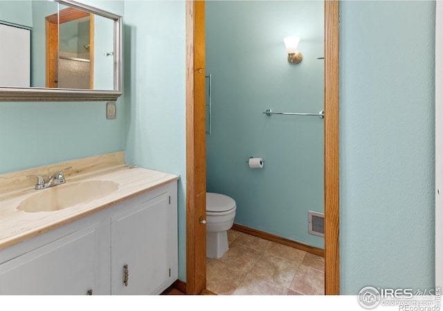 bathroom featuring tile patterned flooring, vanity, a shower with shower door, and toilet