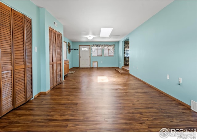 interior space featuring dark hardwood / wood-style flooring and a skylight