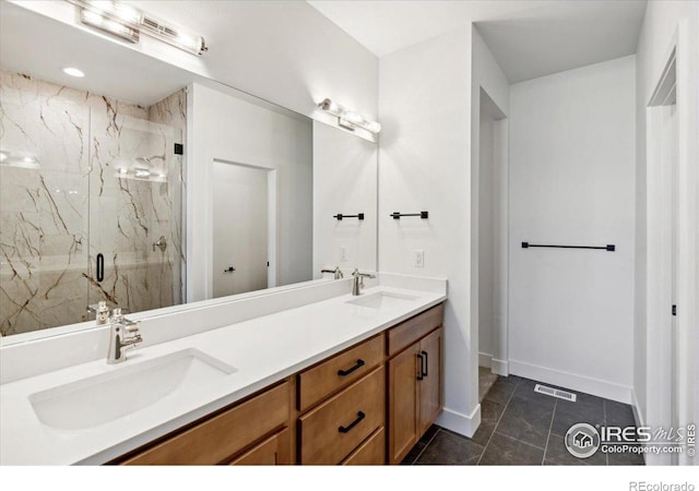 bathroom featuring a shower with door, vanity, and tile patterned flooring