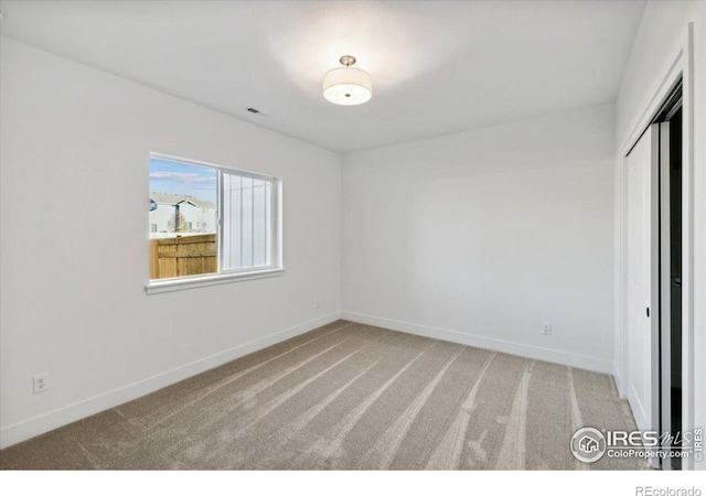 unfurnished bedroom featuring light colored carpet and a closet