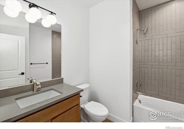 full bathroom featuring vanity, tiled shower / bath combo, and toilet