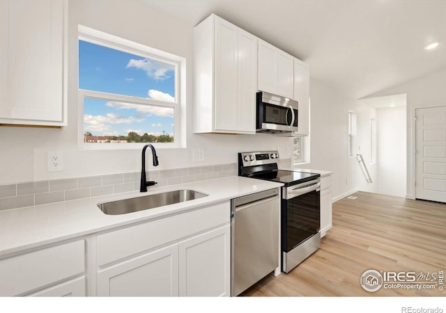 kitchen featuring light hardwood / wood-style floors, sink, white cabinets, and stainless steel appliances