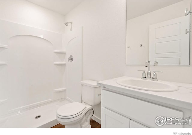 bathroom featuring a shower, toilet, and vanity