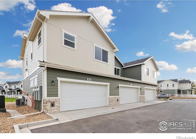 view of front of home with a garage and central AC unit