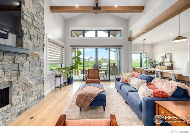 living room featuring high vaulted ceiling, beam ceiling, a fireplace, and light hardwood / wood-style flooring