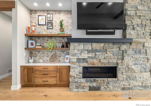 interior space featuring a stone fireplace and light hardwood / wood-style flooring