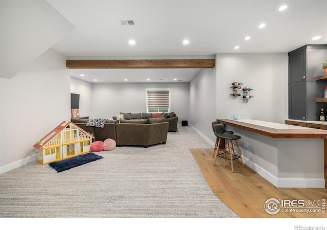 living room featuring beam ceiling and light wood-type flooring