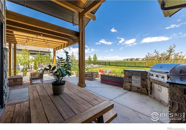 view of terrace with grilling area and an outdoor kitchen