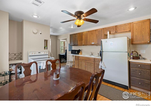 kitchen featuring light hardwood / wood-style floors, sink, ceiling fan, and white appliances