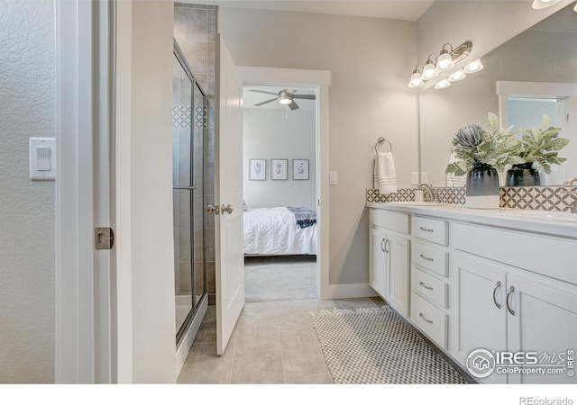 bathroom featuring a shower with shower door, vanity, ceiling fan, and tile patterned floors