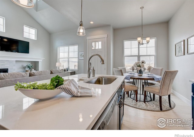 kitchen featuring a notable chandelier, light hardwood / wood-style flooring, dishwasher, pendant lighting, and sink