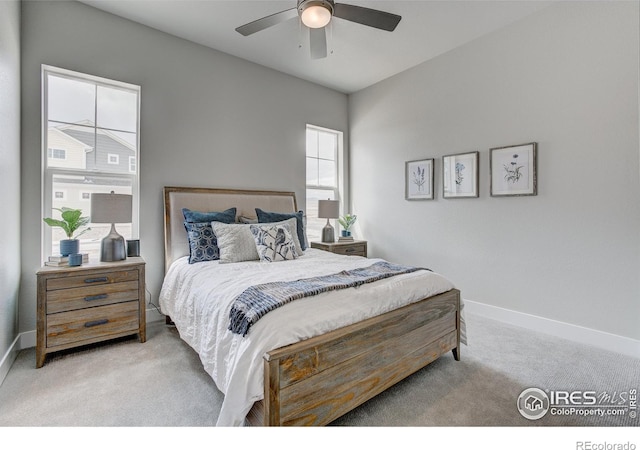 bedroom with multiple windows, light carpet, and ceiling fan