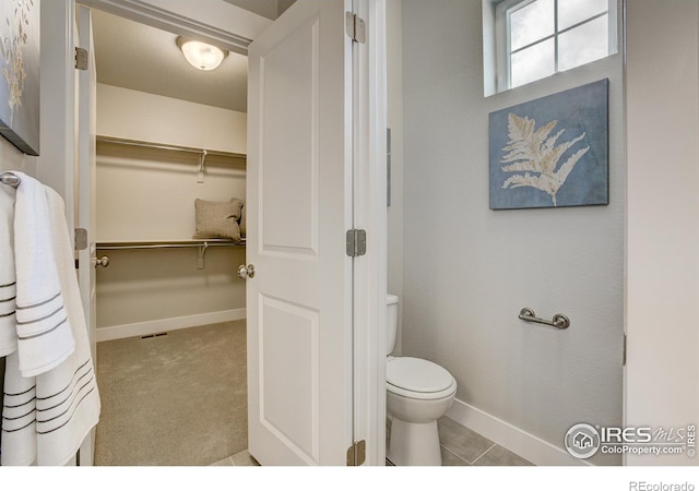 bathroom featuring toilet and tile patterned flooring