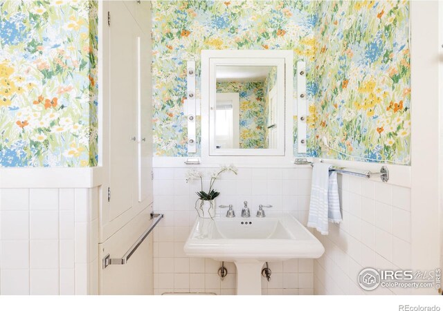 bathroom featuring sink and tile walls