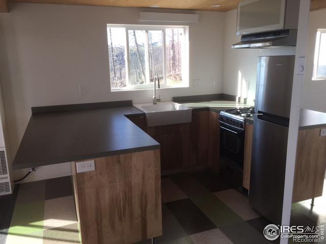 kitchen with gas range gas stove, sink, and stainless steel fridge