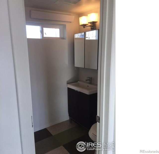 bathroom featuring tile floors, vanity, and toilet