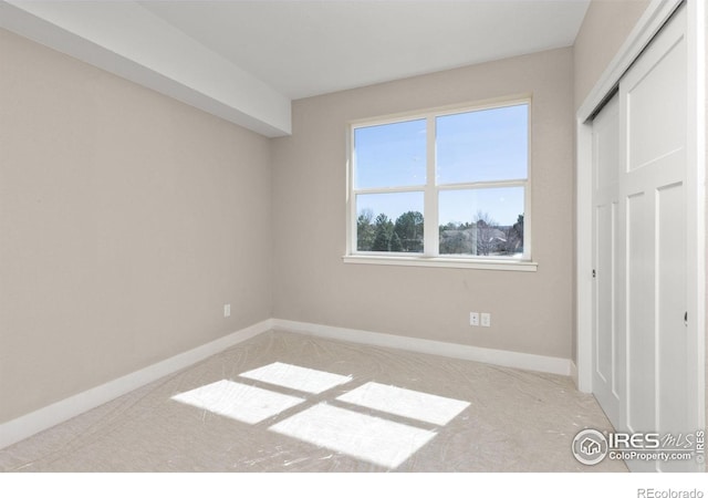 unfurnished bedroom featuring light carpet and a closet