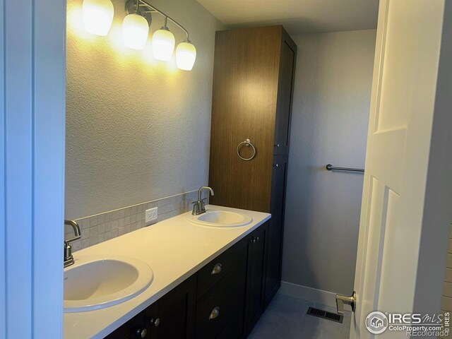 bathroom with tile patterned flooring, vanity, and backsplash