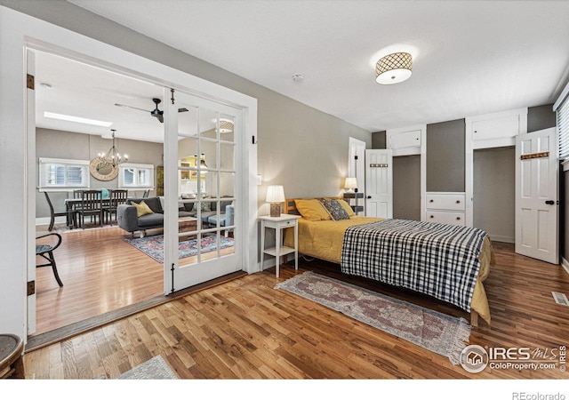 bedroom with hardwood / wood-style floors and an inviting chandelier