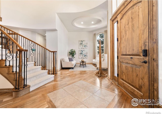 entrance foyer with hardwood / wood-style flooring and a tray ceiling