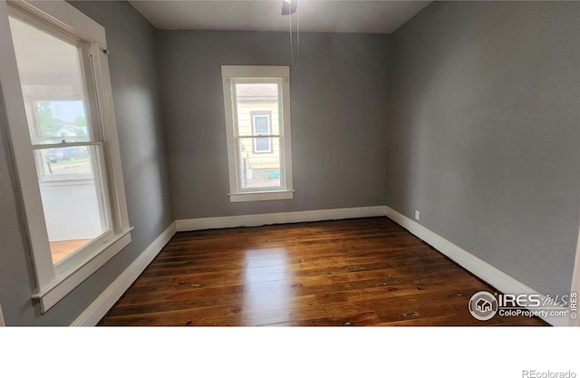 spare room with ceiling fan and dark wood-type flooring