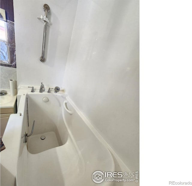 bathroom with vanity and a washtub