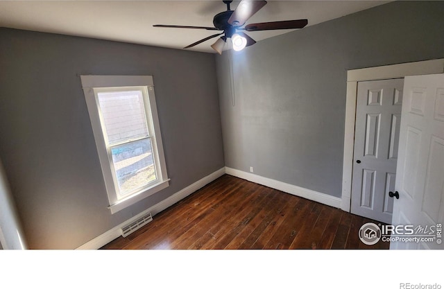 spare room with ceiling fan and dark hardwood / wood-style flooring