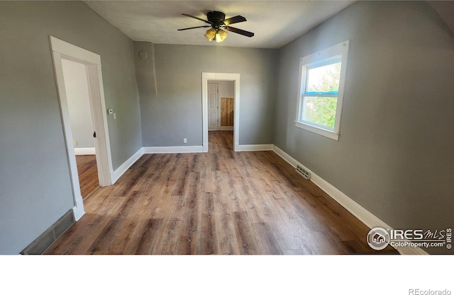 empty room with light wood-type flooring and ceiling fan