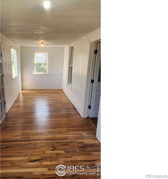 unfurnished room featuring a textured ceiling and dark wood-type flooring