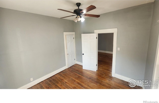 empty room with ceiling fan and dark hardwood / wood-style flooring