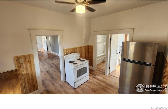 kitchen featuring electric stove, stainless steel refrigerator, light wood-type flooring, and ceiling fan