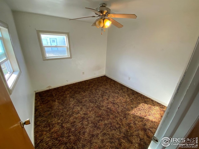 carpeted spare room with ceiling fan