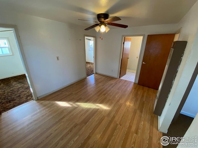 spare room with light wood-type flooring and ceiling fan