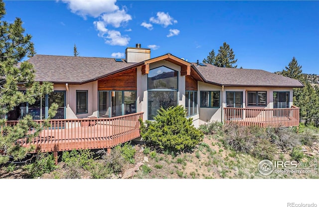 back of house featuring a wooden deck and a sunroom