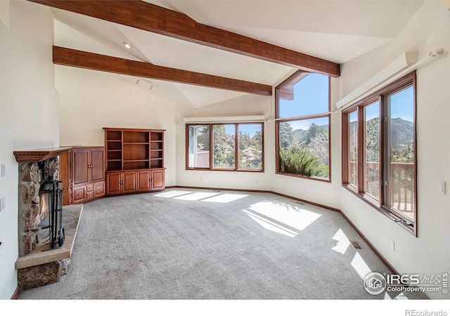 unfurnished living room featuring light carpet, a fireplace, beam ceiling, high vaulted ceiling, and a mountain view