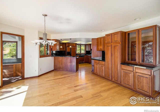 kitchen with decorative light fixtures, a wealth of natural light, and light hardwood / wood-style floors