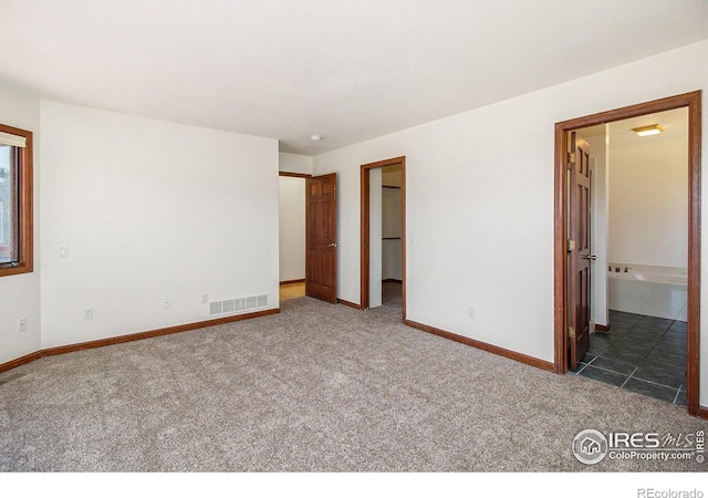 unfurnished room featuring dark carpet