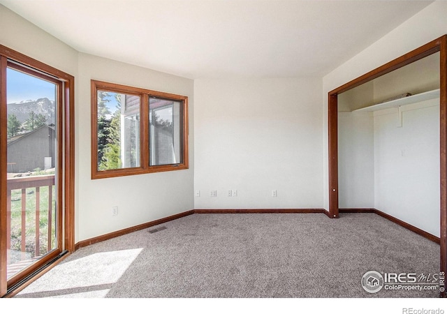 unfurnished bedroom featuring carpet flooring and a mountain view