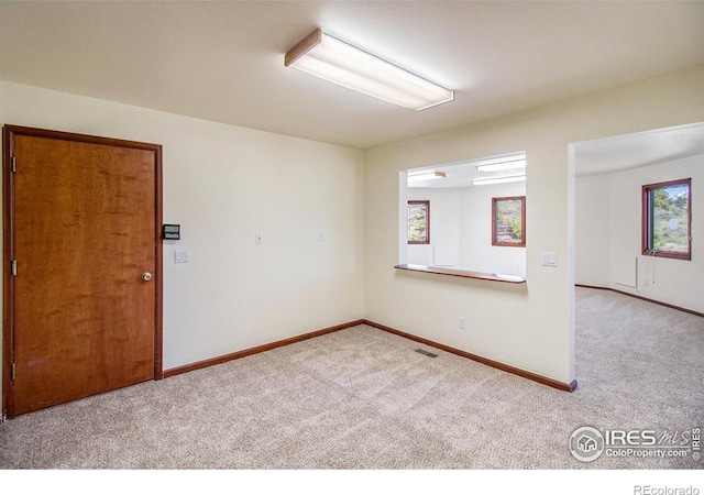 unfurnished room featuring plenty of natural light and light colored carpet