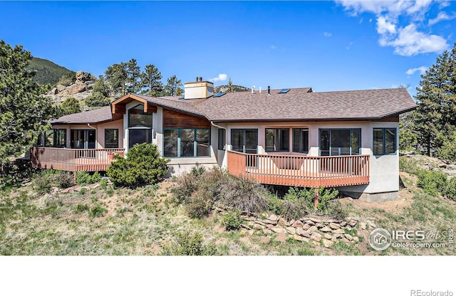 rear view of property featuring a wooden deck