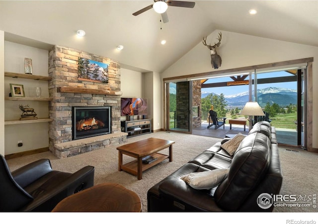 living room with ceiling fan, high vaulted ceiling, carpet floors, a fireplace, and a mountain view