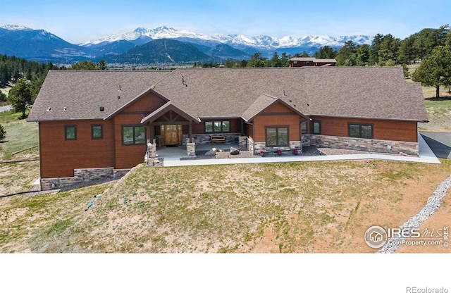 view of front facade featuring a mountain view, a patio, and a front yard