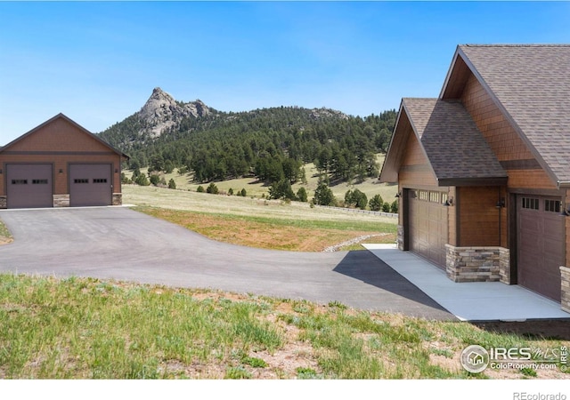 exterior space with a garage, a mountain view, and an outdoor structure