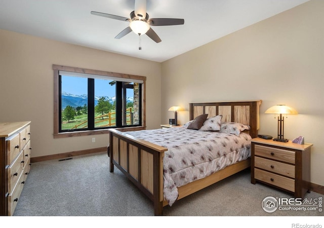 carpeted bedroom featuring a mountain view and ceiling fan