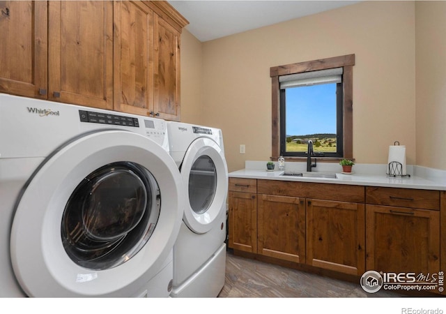 clothes washing area featuring cabinets, separate washer and dryer, and sink