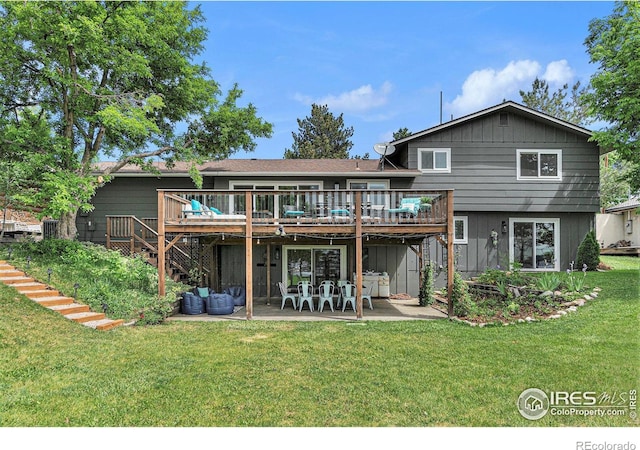 back of property featuring a deck, stairway, a patio area, and a lawn