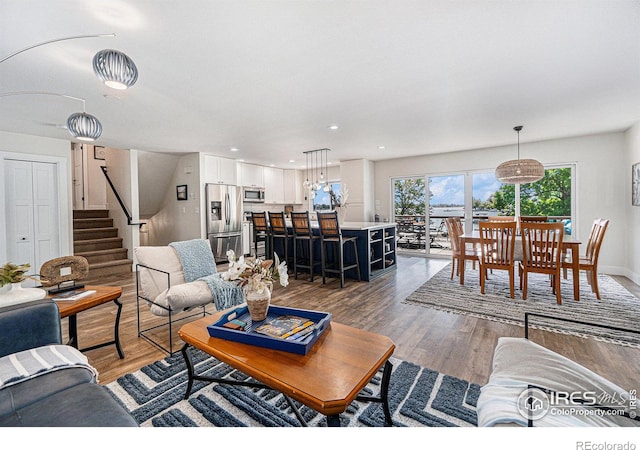 living room featuring recessed lighting, dark wood finished floors, stairway, and baseboards