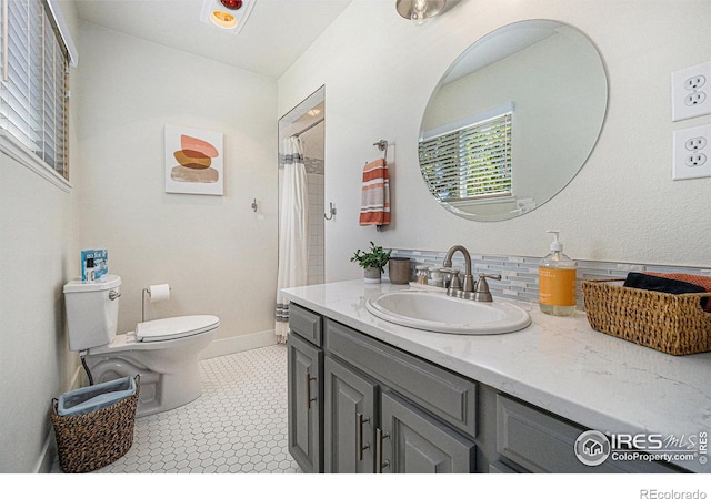 bathroom with curtained shower, vanity, toilet, and baseboards