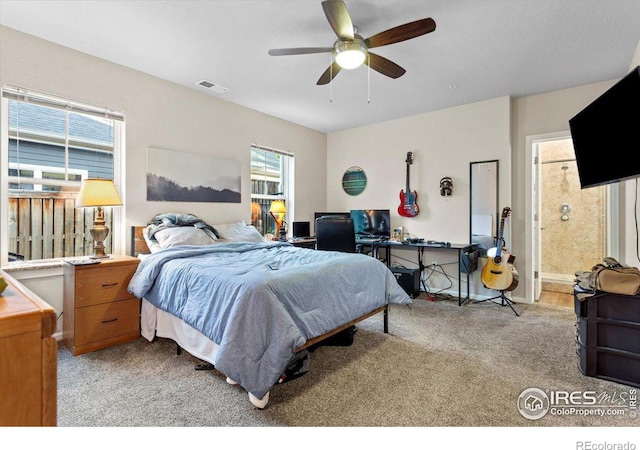 bedroom with connected bathroom, ceiling fan, and light colored carpet